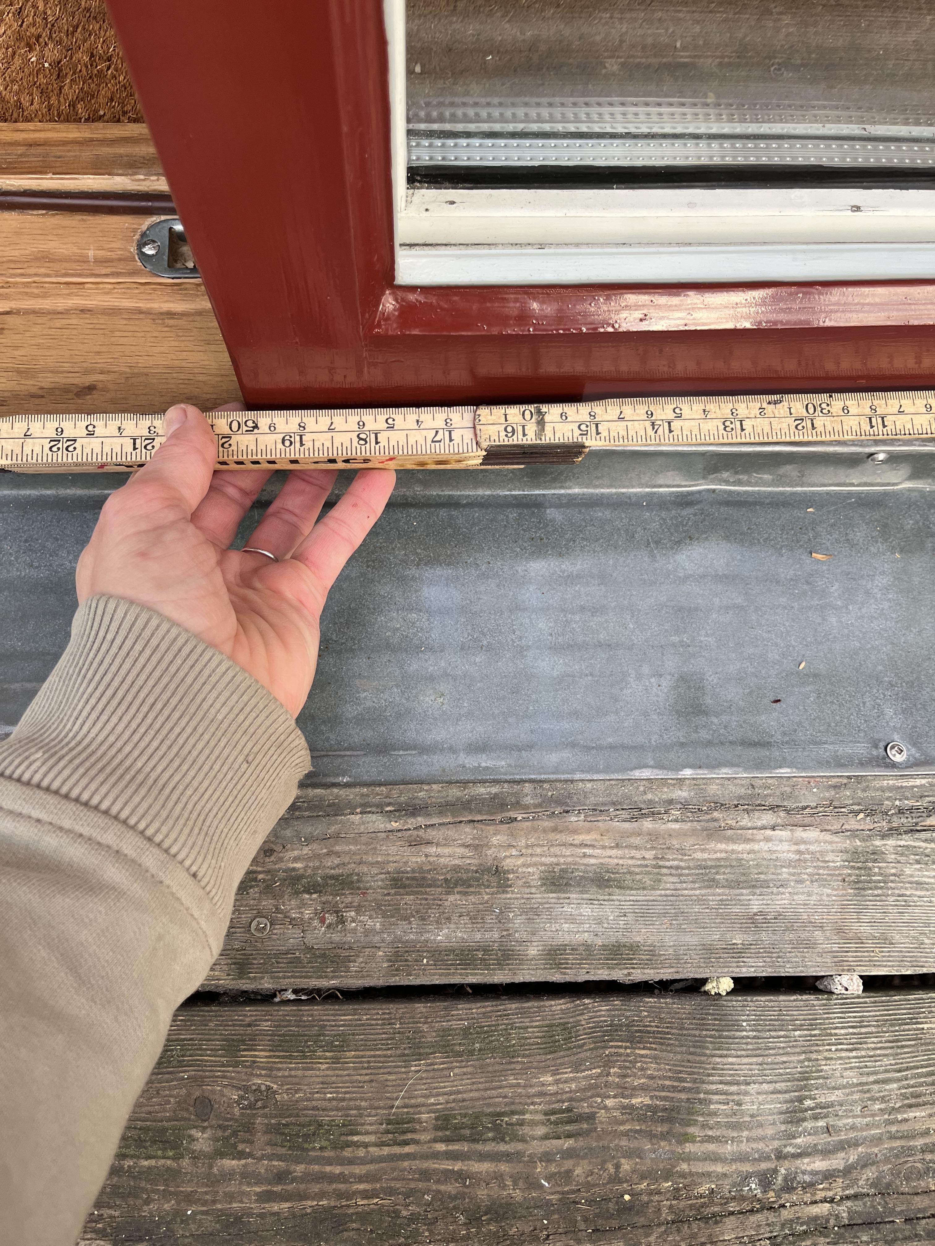 Mätning på plats inför att montera en droppnäsa, på balkongdörrar ett extra skydd för en tidigare rötskadad tröskel.